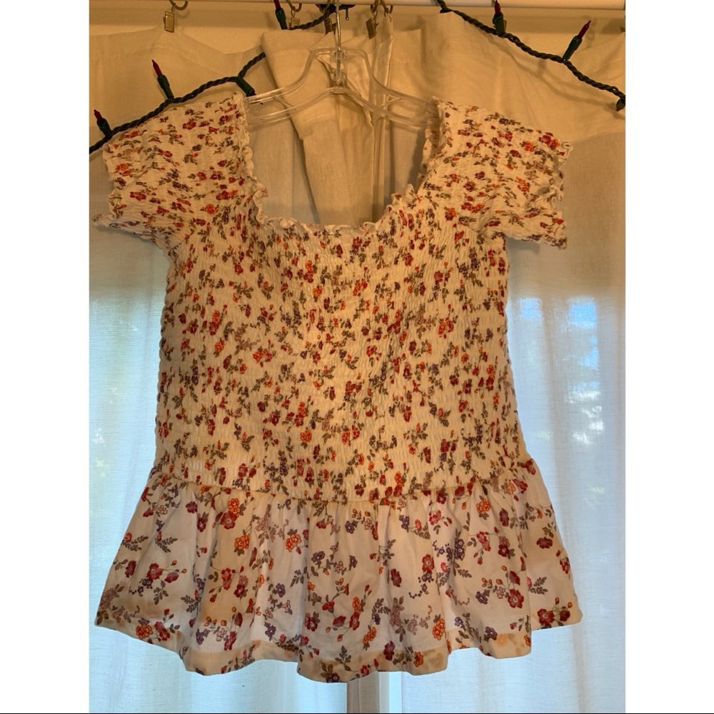 White over the shoulder top. White with purple and pink flowers.